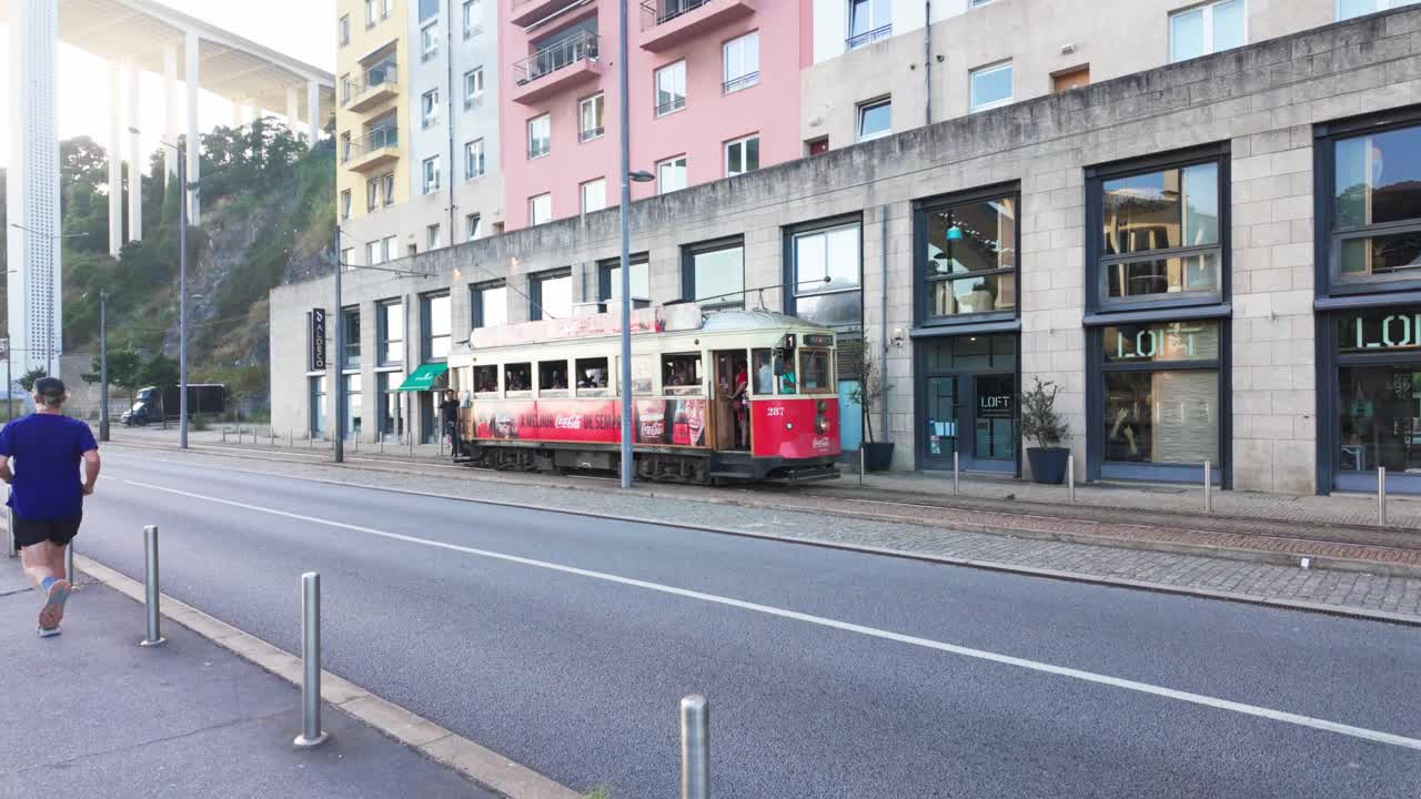 Historic tram in Porto city with Coca-Cola branding, people on board and street view