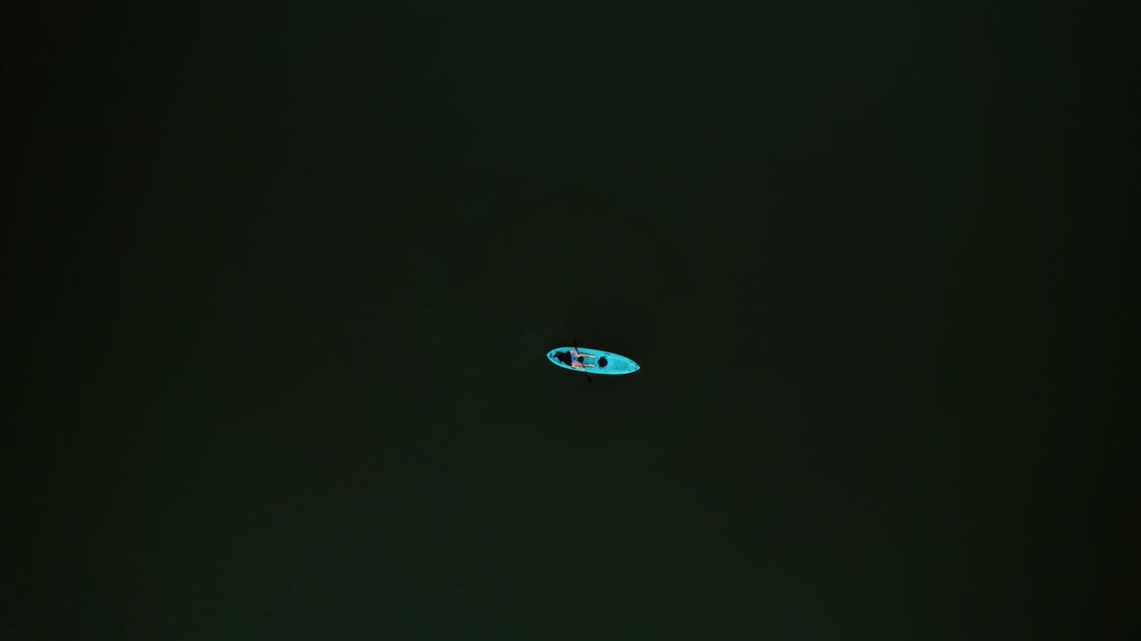 A lone kayak drifts over dark green water in Utah’s Tibble Fork Reservoir Aerial