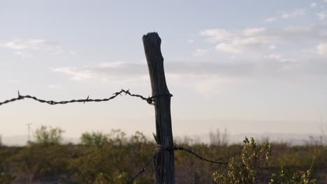 Rack-focus-from-fence-post-to-sky-in-background,-sometime-at-dawn