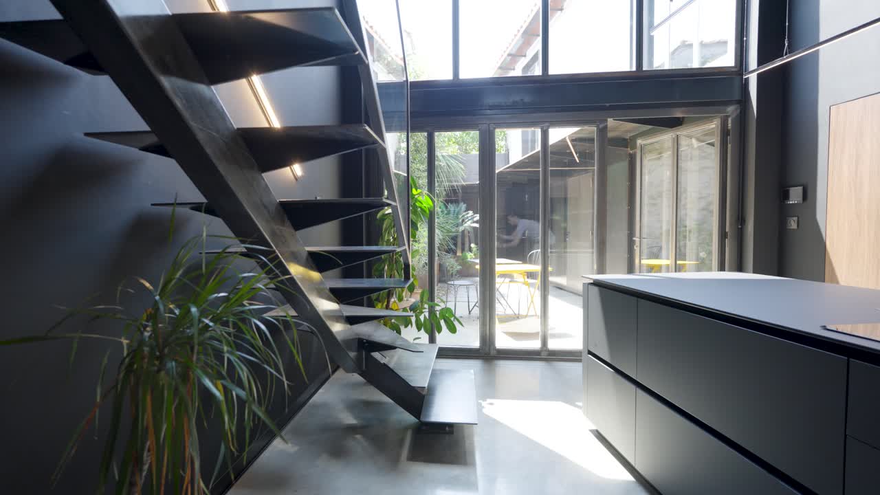 Slow establishing shot of a staircase leading to the garden though sliding doors