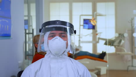 portrait of exhausted doctor in dental office looking on camera