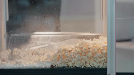 scoop of fluffy popcorn being served at a snack stand