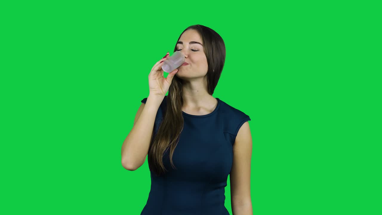 녹색 화면 앞에서 총을 쏘는 섹시한 매력적인 소녀