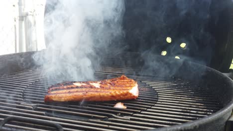 dar la vuelta a un filete de salman sellado a la parrilla y oler el humo de la barbacoa