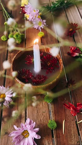 candle and flowers on wooden table