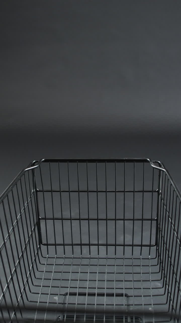 Vertical video of shopping trolley with copy space over grey background
