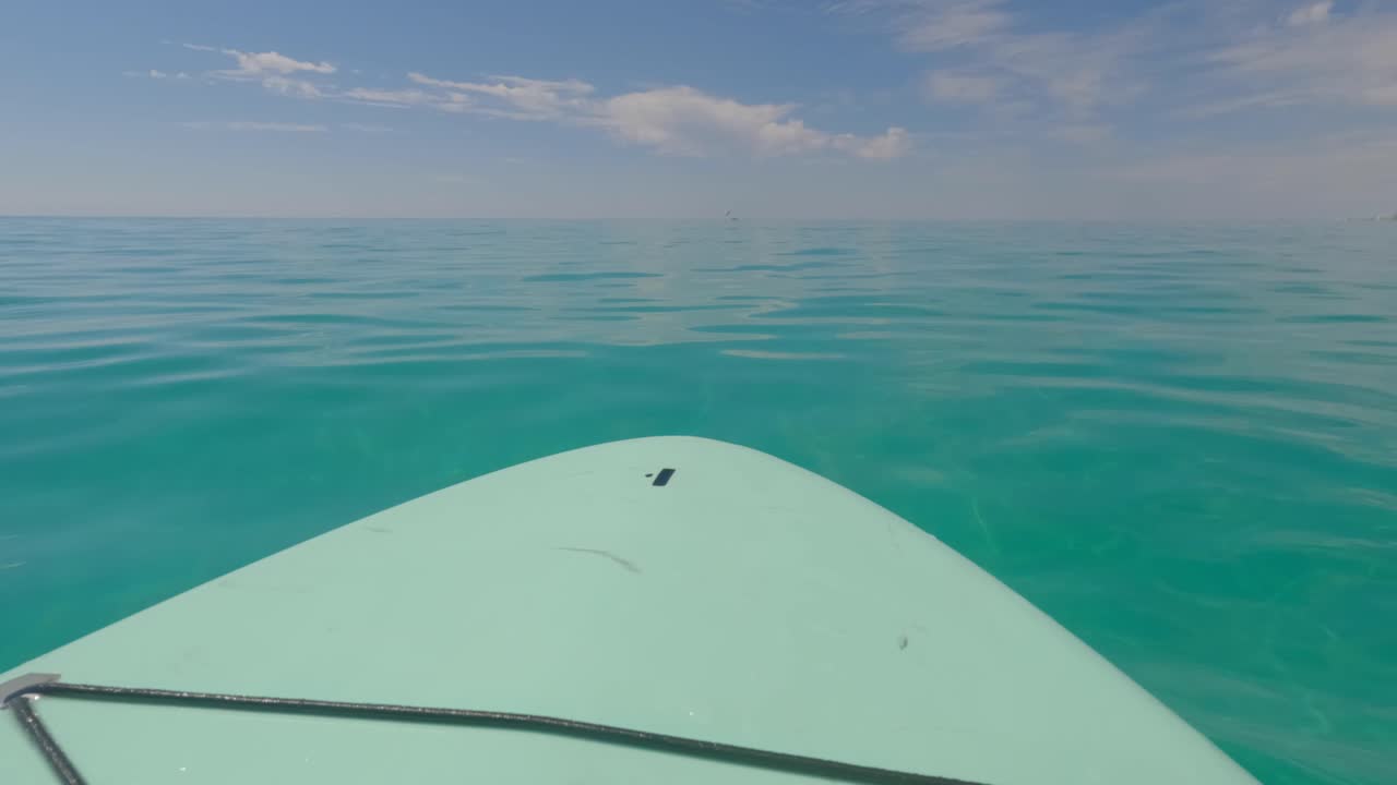 tabla de remo flotando frente a la costa de miramar beach, florida, en el golfo de méxico.