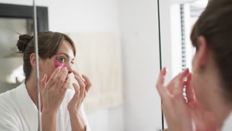 Middle-aged-Caucasian-woman-examines-her-skin-in-the-mirror-at-home