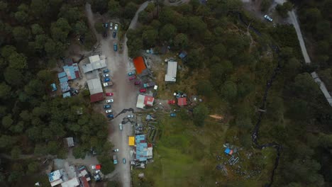 aerial descent toward low income houses in the forrest, low income