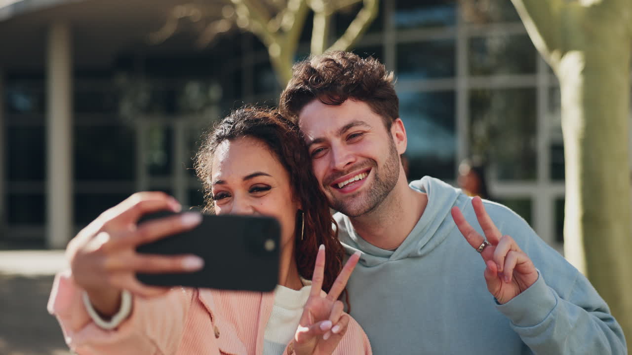 Selfie, segno della pace e una coppia nel campus