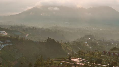 aerial view of hazy morning in tropical countryside of indonesia. mountain landscape, agriculture and countryside. travel concept. 4k drone video.