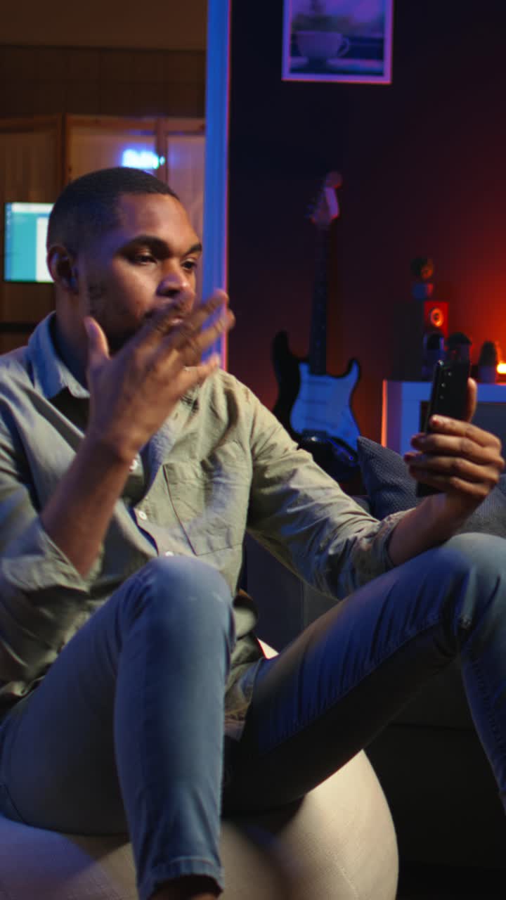 Vertical Video African american guy attends web conference call on laptop sitting at home