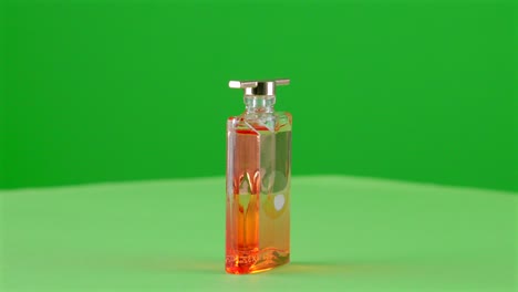 Frasco-De-Perfume-De-Mini-Escala-De-Aroma-De-Fragancia-Dorada-Elegante-Para-Maqueta-En-Un-Plato-Giratorio-Con-Pantalla-Verde-Para-Eliminación-De-Fondo-3d