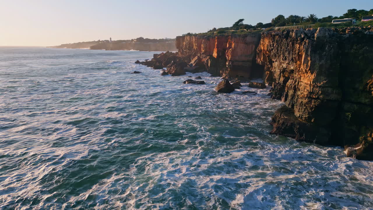 Beautiful panorama rocky shoreline at evening sunlight drone view. Ocean waving