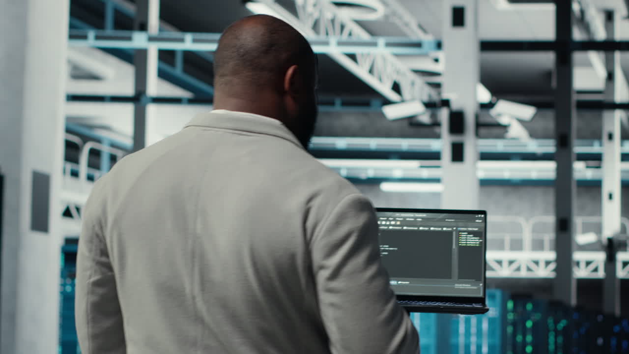 Vertical video Programmers walking in data center coding, doing optimizations using tablet