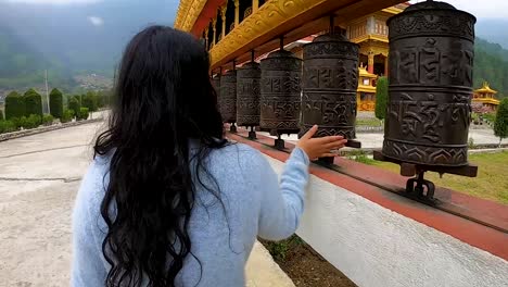 niña girando budismo ruedas sagradas religiosas en el monasterio desde un ángulo plano se toma un video en el monasterio dirang arunachal pradesh india