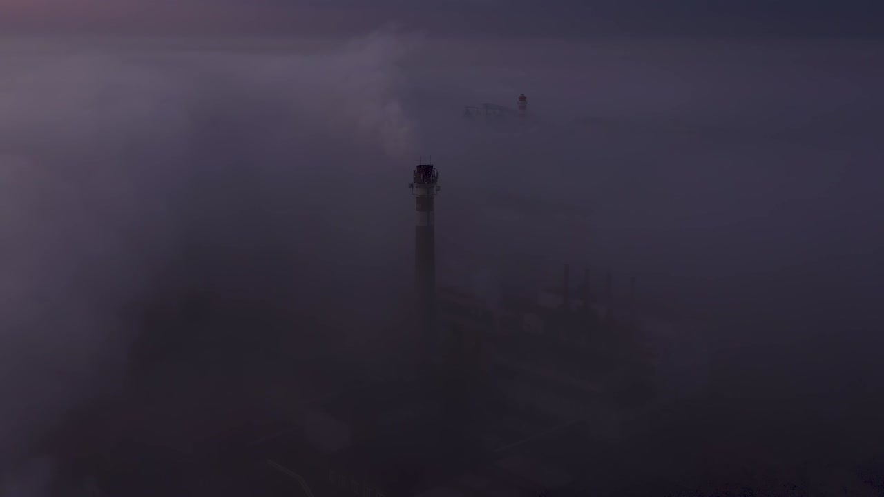 공장 파이프 주변을 날아다니며 해가 뜨는 아침 안개에서 드론 뷰