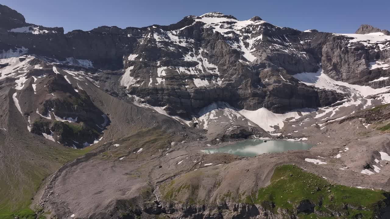 Veduta aerea del Fisetenpass con il Gletscherseeli vicino al Klausenpass in Svizzera, che mostra ghiacciai alpini, pendii rocciosi e un lago di montagna turchese.