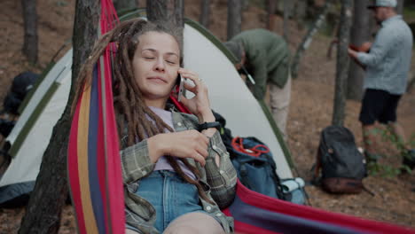 woman relaxing in a hammock at a forest camping trip