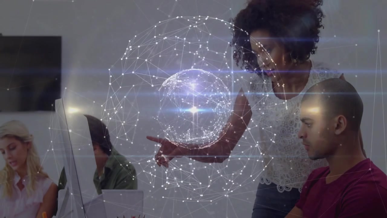 Four coworkers sketching papers and typing at office desk, with technology network hologram overlay