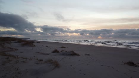 aerial drone flyover at perkone sandy beach baltic sea coastline after the sunset, no people, autumn, spring, relieving shot over the dunes