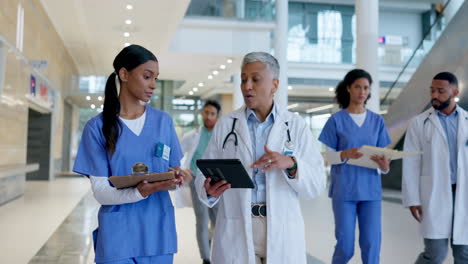 hospital, tableta y equipo de médicos caminando