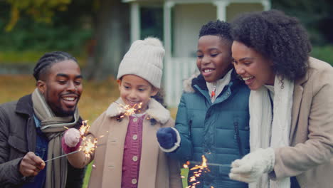 Family-having-fun-with-sparklers-in-autumn-garden-at-home---shot-in-slow-motion