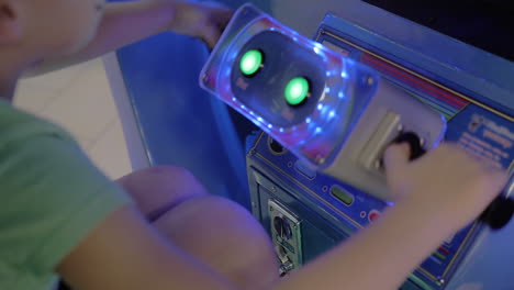 a closeup of a game machine wheel moving by a boy