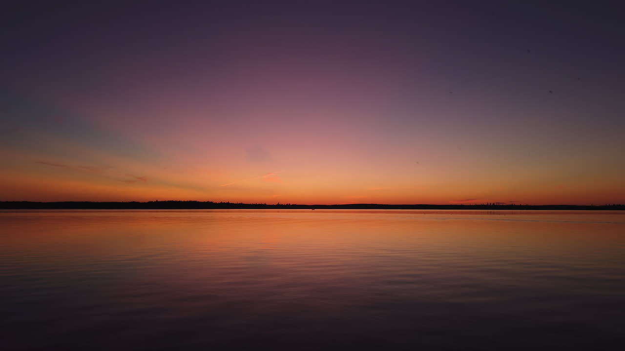 Aerial view of vibrant sunset over lake in Boreal Forest