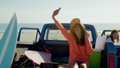 una pareja tomando una selfie con el teléfono móvil cerca del coche 4k