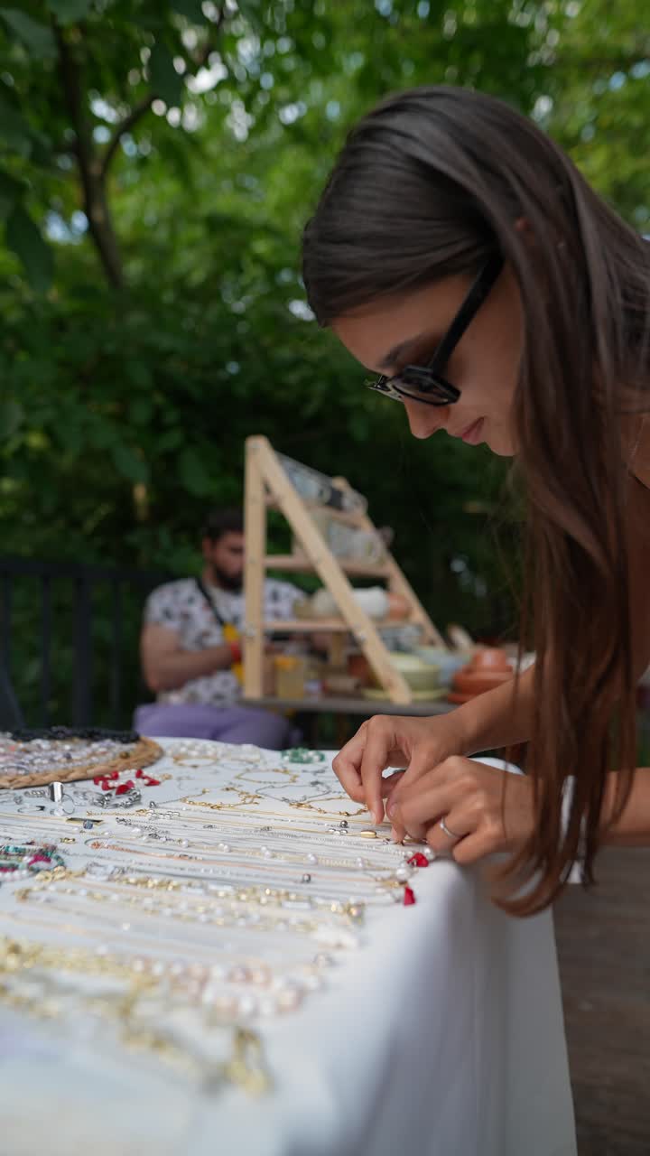 mujer mirando joyas en un mercado al aire libre
