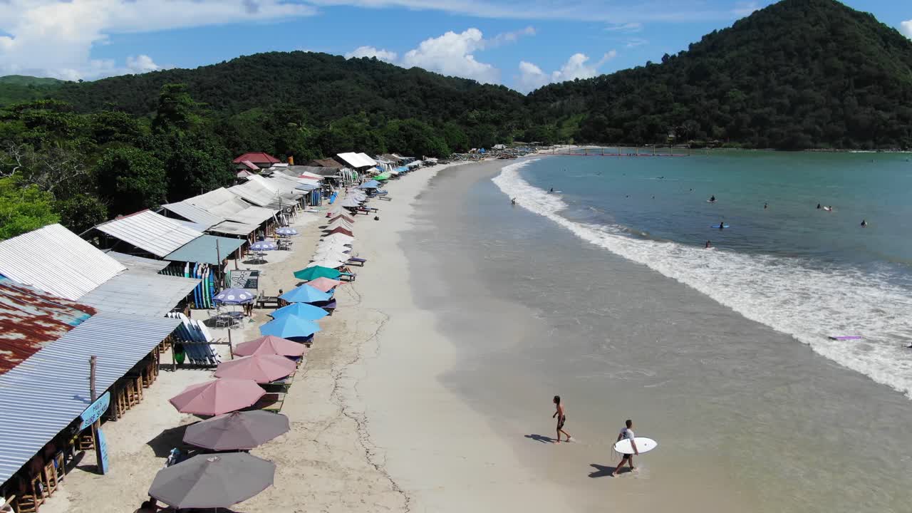 열대 섬의 물 속으로 들어가는 서핑보드를 가진 남자, 화창한 날