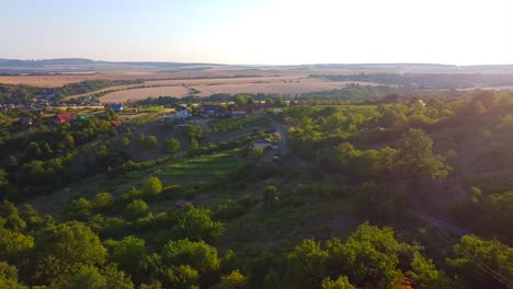 Aerial-Hronsky-Benadik-in-Slovakia,-lens-flare,-town-between-hills-and-trees