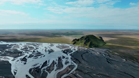 riverbed and green mountain in south iceland - aerial drone shot