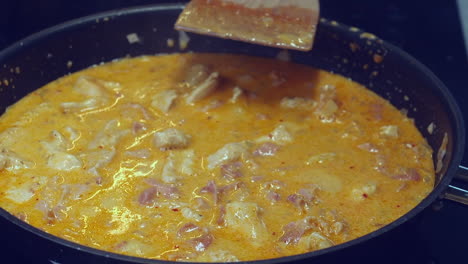 Closeup-view:-Rich-creamy-chicken-curry-simmers-in-pan-on-hot-stove