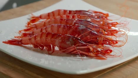 pouring salt over cooked red prawns