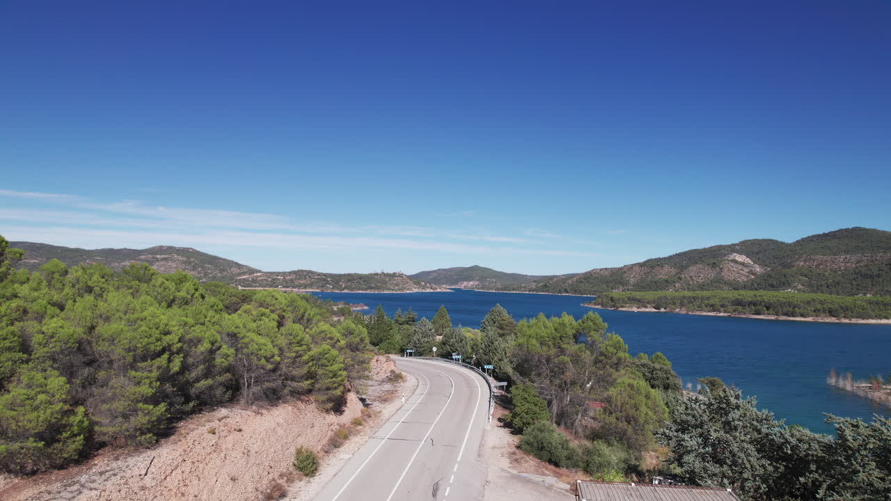 Pedestal shot near abandoned gas station, moving up to reveal the Embalse de Entrepeñas reservoir, Spain