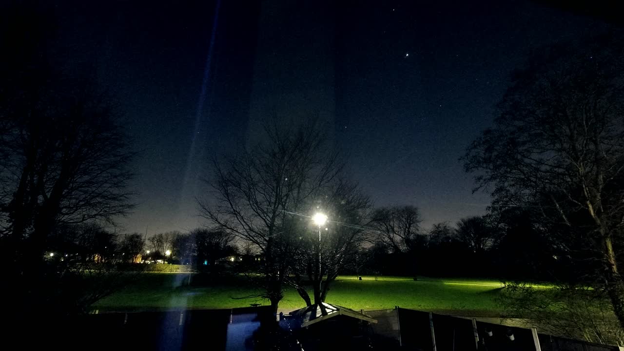 雲が蒸発し、イギリスの住宅地にある野原の星空の夜空のタイムラプスが現れます。