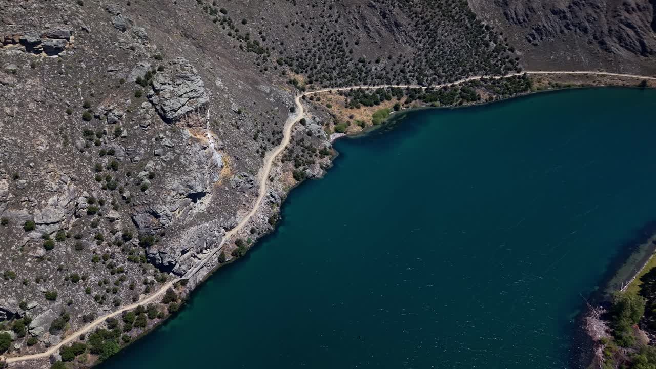 Scenic lakeside trail with rugged terrain and historic landmarks for exploring