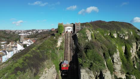 Toma-Aérea-De-Drones-De-Hastings,-Reino-Unido,-Cámara-Volando-Sobre-La-Playa-Stade,-Barcos-De-Pesca-Y-High-Street,-Lejos-Del-Ferrocarril-East-Hill-Cliff