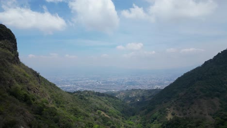 beautiful shot of drone approaching valley with costa rican capitol seen in distance