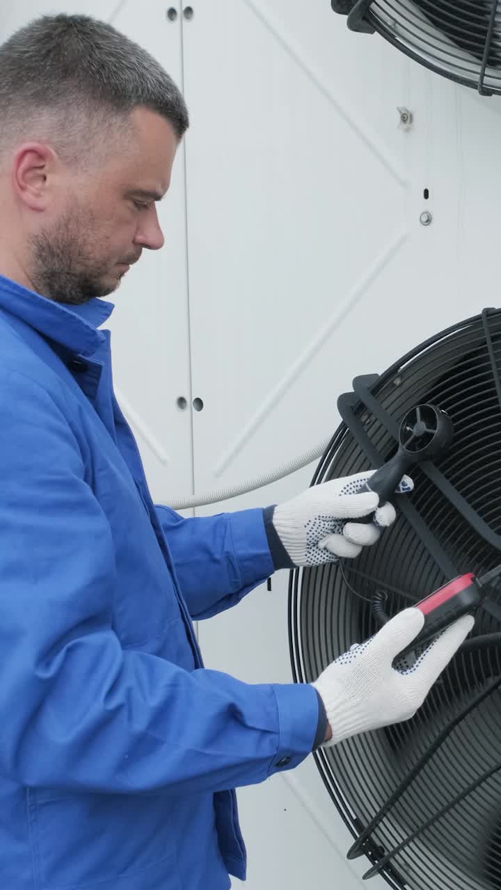 HVAC Technician Inspecting Air Conditioning Unit with Anemometer