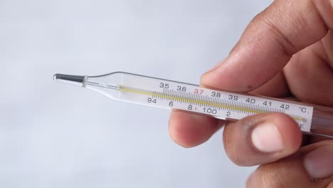 person holding a glass thermometer