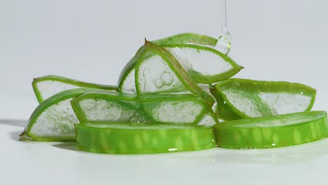 transparent extract gel flows through the aloe vera sliced on white background. natural medical plant for organic cosmetics, alternative medicine