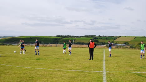 soccer players practicing on field with coach, preparing for match in countryside