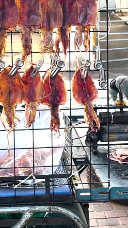 street vendor preparing and selling dried squid