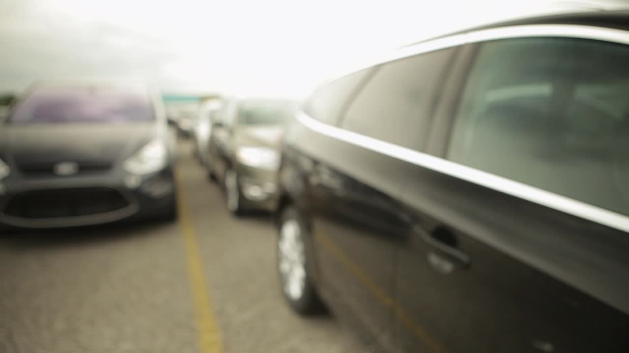 Panning shot of a line of parked cars with a shallow focus and a blurry background