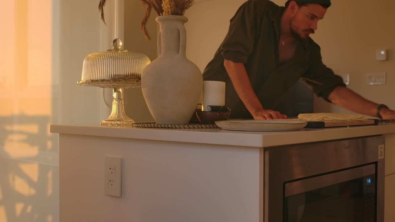 Man Cleaning Kitchen Countertop in Golden Hour Natural Light - Static