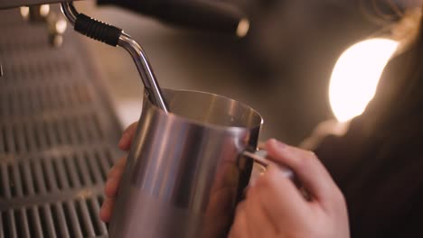 barista steaming milk with steam wand