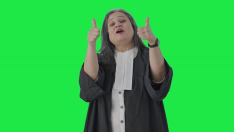 feliz abogada india senior mostrando los pulgares hacia arriba pantalla verde